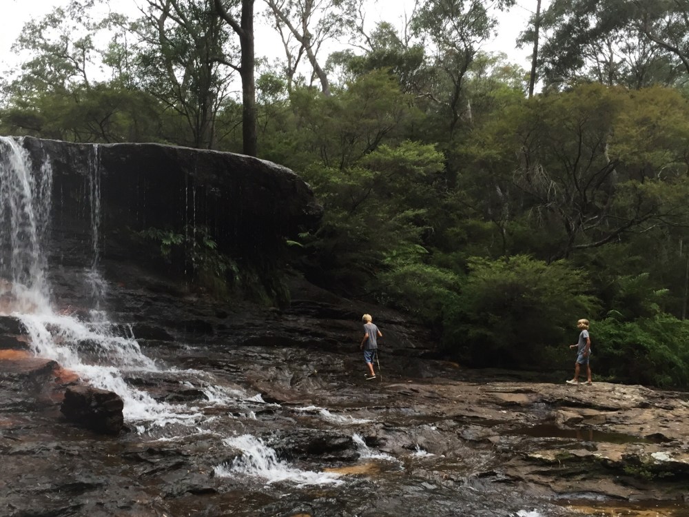 Boys walking in waterfall